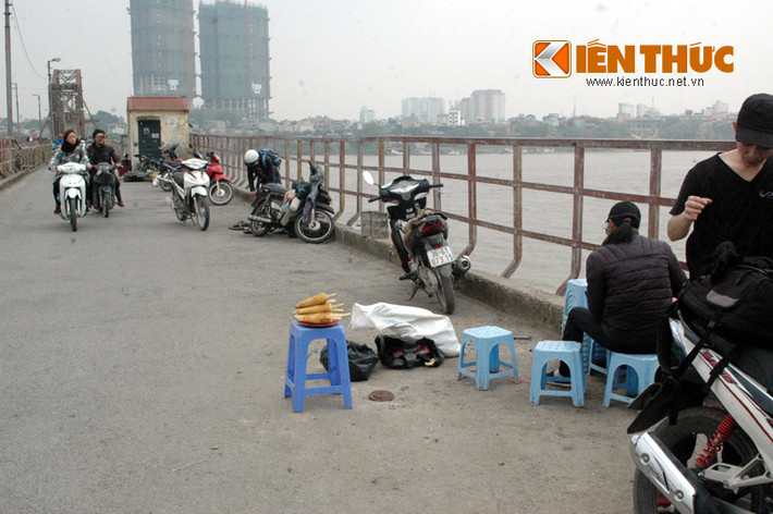 Phần đường dành riêng cho xe máy qua lại trên cầu đang biến thành cái chợ khi một số người bày hàng quán ở đây.