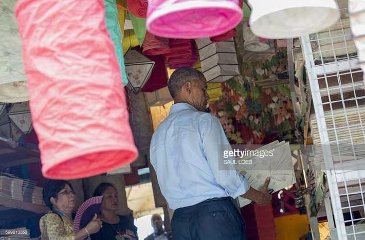 Ông Obama đang tự mình chọn những món quà lưu niệm tại một cửa hàng ở Luang Prabang.