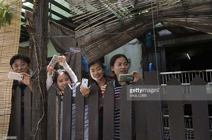 Người dân Lào dùng điện thoại ghi lại trong lúc ông Obama đang mua đồ lưu niệm ở Luang Prabang.