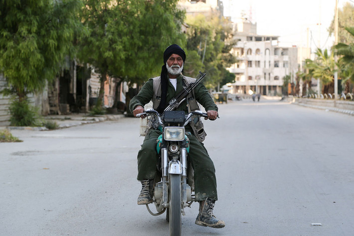 Có nhiều nhóm nổi dậy hiện diện ở Đông Ghouta này, bao gồm Jaish al-Islam, al-Rahman Corps, al-Qaeda hay Quân đội Syria Tự do (FSA). Ảnh: Một chiến binh FSA lái xe máy ra chiến tuyến.