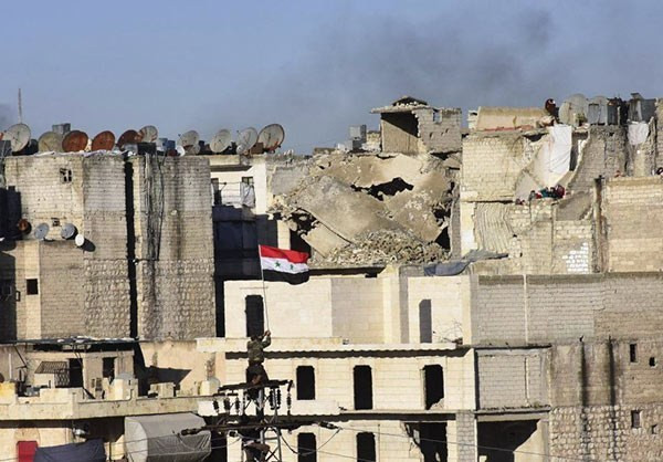 Lá cờ chính phủ Syria tung bay trên nóc tòa nhà ở Aleppo. Ảnh FNA