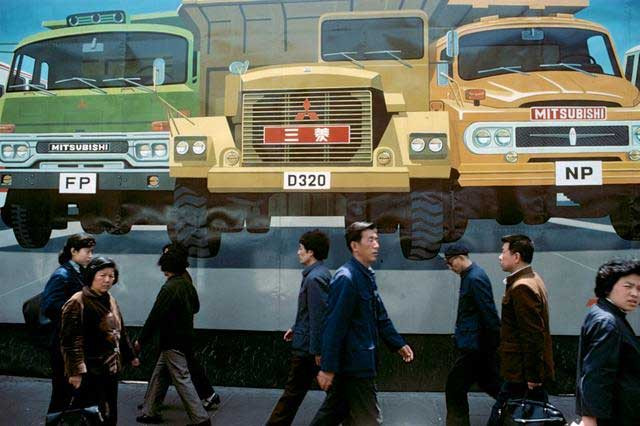 Người dân đi ngang qua chỗ quảng cáo xe hơi Nhật Bản ở Thượng Hải. Ảnh Sina