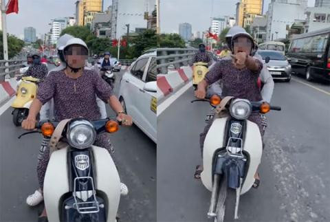 Vô tình làm rơi chiếc túi giữ nhiệt bên trong là chai nước, một thanh niên đã dừng xe xuống đường để nhặt lại nhưng lại bị người phụ nữ này nhanh hơn một bước.