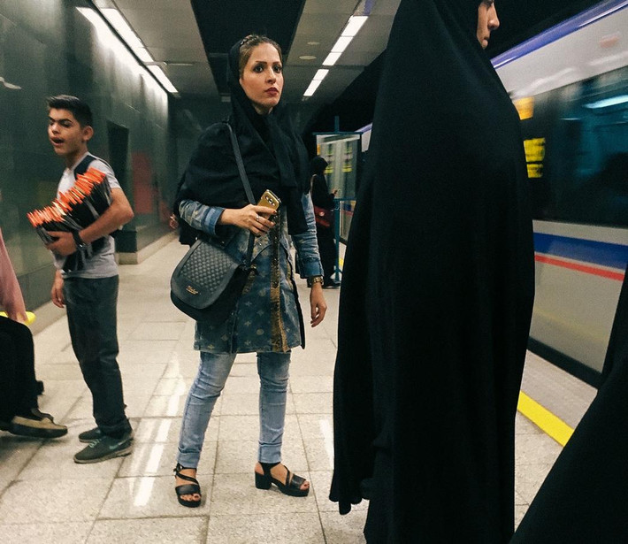 Một cô gái trẻ tuổi ở Quốc gia Hồi giáo Iran ăn vận hiện đại và xài điện thoại iPhone.