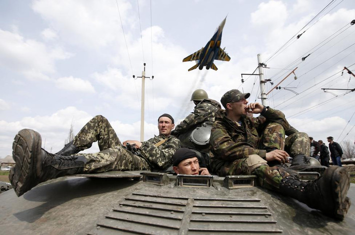 Các quân nhân Ukraine ngồi trên một xe bọc thép chở quân trên con đường ở thành phố Kramatorsk, miền đông Ukraine.