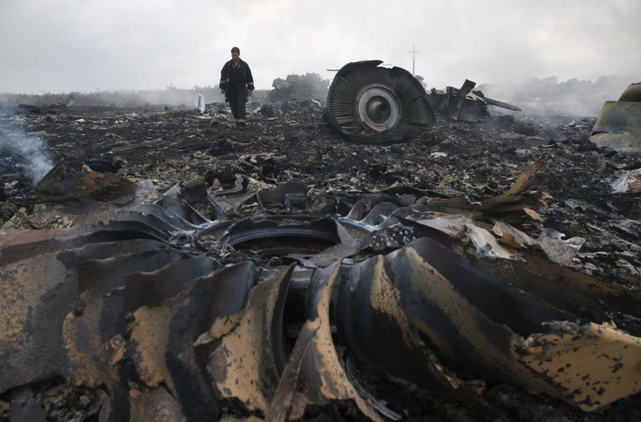 Thành viên Bộ Tình trạng Khẩn cấp Ukraine đi giữa hiện trường vụ thảm kịch rơi máy bay MH17 của hãng hàng không Malaysia Airlines ngày 17/7/2014, khiến toàn bộ 298 hành khách và phi hành đoàn thiệt mạng. Ảnh chụp gần ngôi làng Grabovo, tỉnh Donetsk.