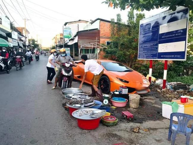 Một anh bán cá lề đường xỏ ủng nhìn khá "hai lúa", tuy nhiên chiếc siêu xe màu cam đỗ sau anh lại mới là điều khiến ai cũng "sốc".