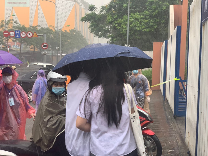 Mưa lạnh, 2 thí sinh nép vào nhau.