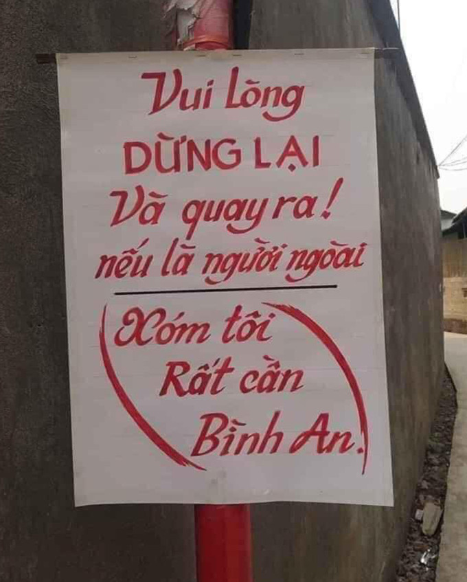 Một khu dân cư treo luôn biển nhắc nhở cả người trong xóm không nên ra ngoài nhiều.
