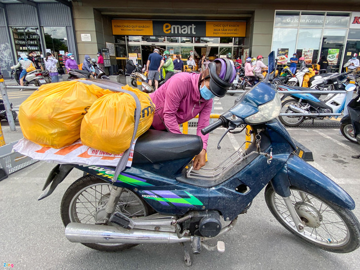 Chị Nguyễn Thị Kim Nhung (ngụ Gò Vấp) đang chở những túi hàng vừa mua được từ siêu thị. Chị đến từ 9h, mua hàng hết 30 phút và phải chờ gần 3 giờ mới có thể thanh toán được. "Thấy đông đúc cũng lo lắng nhưng hiện tại không nhiều siêu thị còn mở cửa, đành phải chịu đến đây mua thôi", chị Nhung chia sẻ.