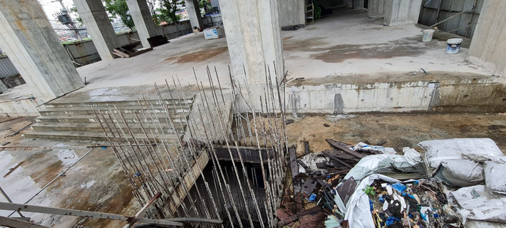 Bê tông cốt thép bắt đầu hoen gỉ, xung quanh là rác thải.