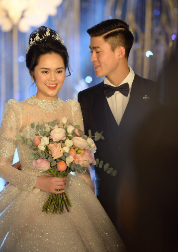 Về đám cưới của cầu thủ Duy Mạnh, váy cưới của nàng WAG Quỳnh Anh được đặt may riêng theo yêu cầu. Váy được làm theo phong cách 2 trong 1, có thể thay đổi tùng váy để cô dâu thuận tiện trong việc di chuyển.