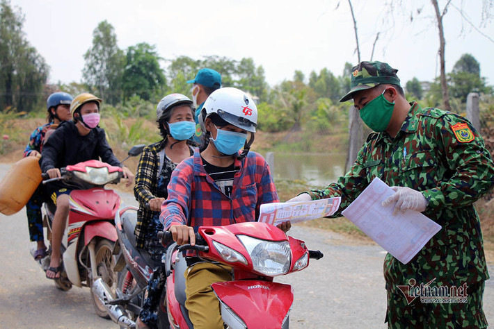 Tuyên truyền phát tở rơi cho người dân trong khu vực để khuyến cáo sự nguy hiểm của COVID-19 cũng như cách phòng tránh. Nguồn ảnh: Vietnamnet.