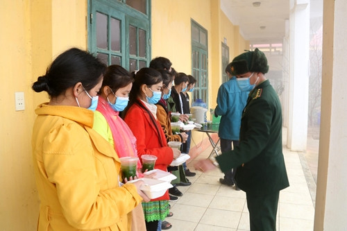 Phát cơm cho người dân trong khu vực cách ly sau khi trở về từ nước ngoài qua đường bộ. Nguồn ảnh: QĐND.