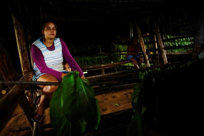 Bà mẹ trẻ ngồi cạnh cậu con trai 3 tuổi đang nghỉ trong lúc làm việc. Ảnh Reuters