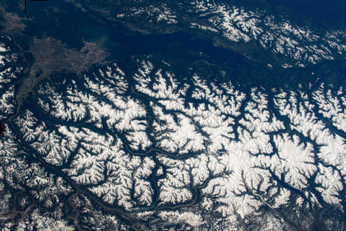 Cảnh tượng ngoạn mục của Dãy núi Duyên hải Thái Bình Dương (Coast Mountains) ở British Columbia nhìn từ không gian và thành phố Vancouver của Canada ở góc trái bức ảnh.