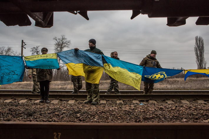Các nhà hoạt động giơ cờ Ukraine khỏi đoàn tàu chở than bị chặn lại ở nhà ga Kryvyi Torets thuộc làng Shcherbynivka. Ảnh USN