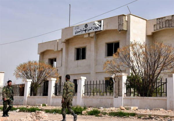 Hai người lính Syria tuần tra trước một tòa nhà. Ảnh FNA