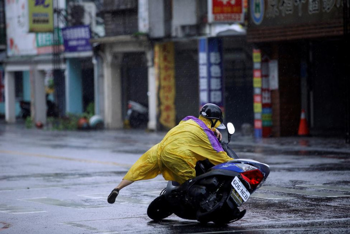 Người phụ nữ đi xe máy điện bị trượt ngã do gió to và mưa lớn gây ra bởi siêu bão Megi đổ bộ vào Hualien, đông Đài Loan hôm 26/9/2016.