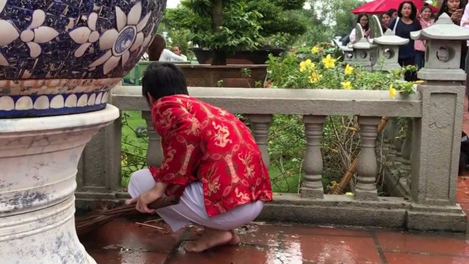 Hình ảnh này của Hoài Linh sau cơn mưa nặng hạt đã gây xúc động mạnh cho mọi người có mặt tại đền thờ Tổ nghề. Nghệ sĩ đi chân trần, tự tay dọn dẹp rác bẩn.
