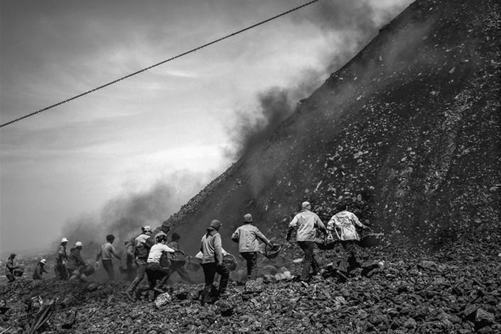 Không đợi đống đất lắng xuống, những người thu gom chạy về phía ngọn đồi, bỏ qua những rủi ro từ những mảnh vỡ rơi xuống ở thành phố Bình Đỉnh Sơn, tỉnh Hà Nam, Trung Quốc, tháng 2/2017. Đây là một trong những bức ảnh ghi lại cuộc sống xung quanh khu vực khai thác và những ngọn đồi phế thải giữa năm 1998-2009, theo CaixingGlobal.