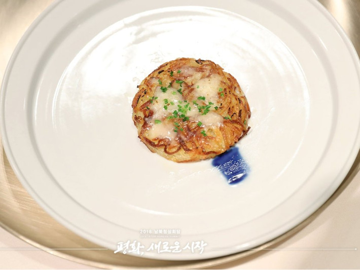 Sau hai món ăn truyền thống của Hàn Quốc thì món thứ ba trong tiệc chiêu đãi là Rosti - một món ăn nổi tiếng của Thụy Sĩ được làm từ khoai tây nghiền. Dường như các đầu bếp Hàn Quốc nắm rõ khoảng thời gian học tập và sinh sống ở Thụy Sĩ của ông Kim Jong-un và món ăn này sẽ gợi nhớ lại cho nhà lãnh đạo Triều Tiên một vài ký ước về thời còn học tập tại quốc gia châu Âu này. Nguồn ảnh: Reuters.