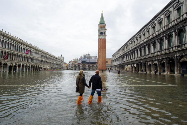 Tuy nhiên, Venice có nguy cơ biến mất trong vòng 20 năm nữa vì mỗi năm thành phố này lún thêm 1-2mm. Ảnh: Đôi nam nữ dắt tay nhau đi ở quảng trường Piazza San Marco trong mùa nước lũ năm 2013. Ảnh The Sun