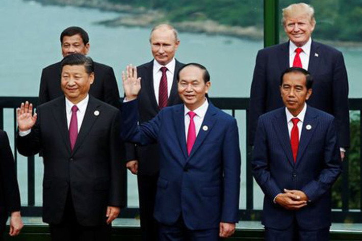 Ông Trump và ông Putin đứng cạnh nhau khi các nhà lãnh đạo kinh tế APEC chụp ảnh lưu niệm. Ảnh: Reuters.