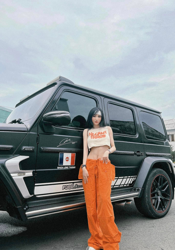 Vợ đại gia Minh Nhựa thường xuyên xuất hiện bên siêu xe đắt đỏ cùng chồng trong những trang phục bắt mắt.