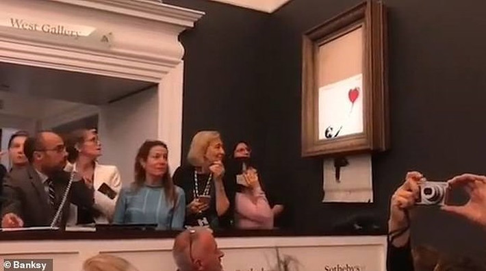 Tuy nhiên ngay sau đó, bức tranh từ từ tụt xuống và bị cắt thành nhiều mảnh. Ảnh: Banksy.