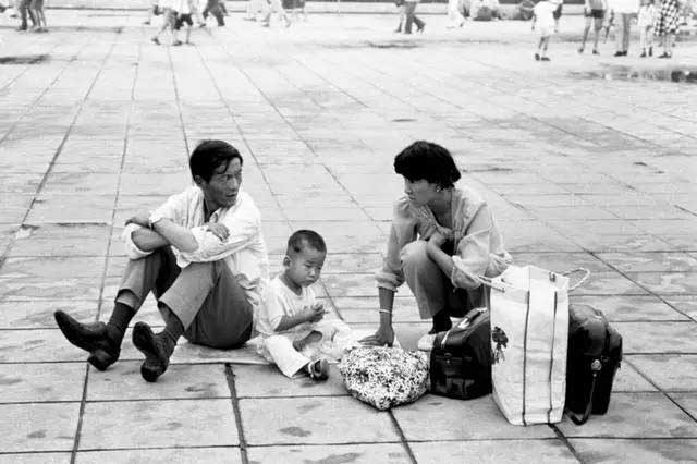 Một gia đình nhỏ ngồi bệt xuống đất sau khi đi bộ mỏi chân. Ảnh Ifeng