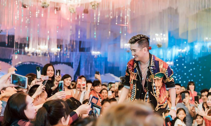 Ngay từ khi bước xuống xe, Mr Đàm đã khiến fan nháo nhác bởi hình ảnh sang chảnh trong bộ vest đen đính kim sa lấp lánh cùng loạt phụ kiện hàng hiệu đắt đỏ. Anh nhận được sự chào đón nồng nhiệt từ phía chủ nhà và những người dân xung quanh khu vực diễn ra đám cưới.
