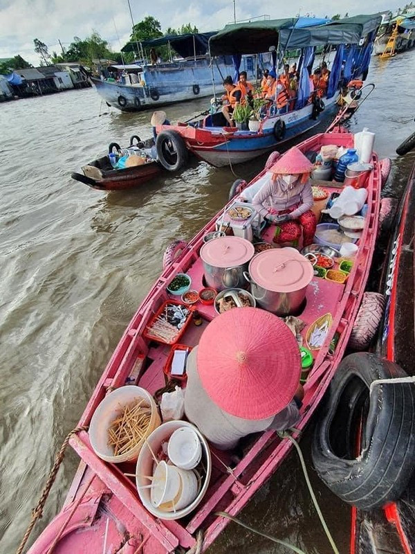 Khác với những chiếc ghe thông thường, chiếc ghe bún riêu này ở chợ nổi Cái Răng được sơn màu hồng bắt mắt, ngồi bên trong là cô bán bún với chiếc nón lá màu hồng dễ thương không kém. Ảnh: Phạm Đỗ Minh Trung