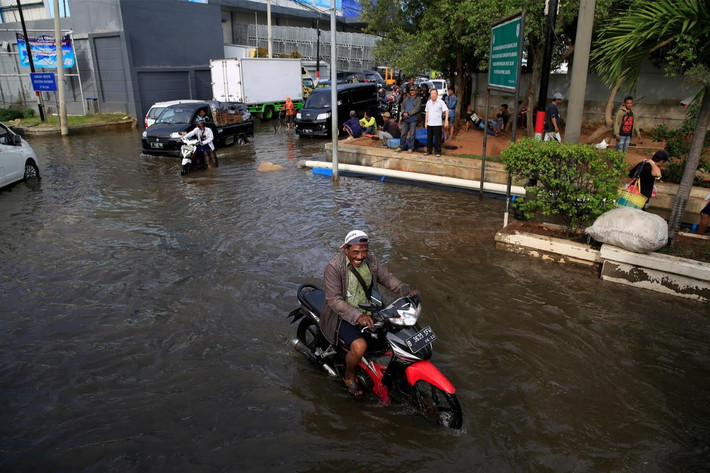 Một mặt, người dân các khu vực ven biển của Indonesia phải đối phó với biến đổi khí hậu khiến mực nước biển dâng cao, mặt khác việc khai thác nước ngầm để sử dụng trong các thành phố lớn như thủ đô Jakarta lại là nguyên nhân làm đất dọc bờ biển sụt lún. Trong ảnh, thủy triều lên tại cảng cá Muara Baru ở Jakarta.