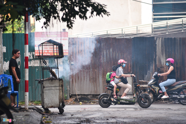 Trẻ nhỏ đi qua phải quay mặt né tránh khói xộc vào mặt.