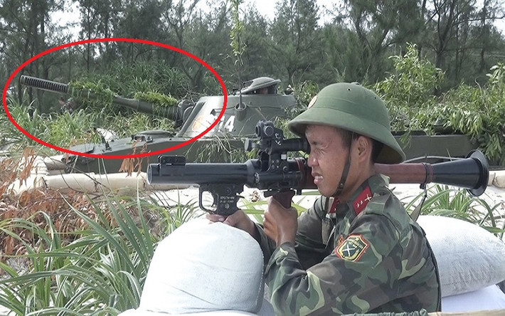 Và dựa trên tìm hiểu của Kiến Thức, khẩu pháo “lạ” trên PT-76 tham gia diễn tập ở Quảng Trị hóa ra có một lai lịch khá đặc biệt khi nó chính là tiền thân của pháo D-56TS hiện nay và có tên mã là D-56T. Trong ảnh khoanh đỏ chính là pháo D-56T với thiết kế giảm giật đầu khác biệt hoàn toàn so với D-56TS. Nguồn ảnh: Báo Quảng Trị