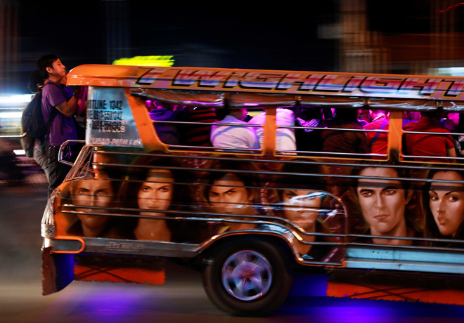Người đi làm đang phải bám vào sau một chiếc xe jeepney đã hết chỗ ở thành phố Cainta. Phương tiện công cộng ở Philippines không đủ để đáp ứng nhu cầu đi lại. Đường sắt đô thị có phạm vi hoạt động hạn chế. Tàu xe thường xuyên hỏng và hàng đợi kéo dài lên mặt đường vốn dày đặc khí thải xe cộ. Ảnh: Reuters.