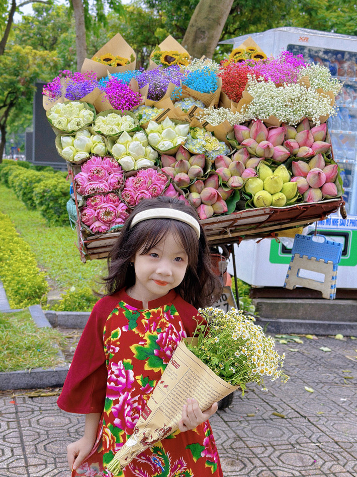 Thay vì chụp ảnh trên đường Phan Đình Phùng, em bé được dì check in quanh Hồ Tây cùng những gánh hàng hoa, hoàng hôn bên hồ... Ảnh: Vietnamnet