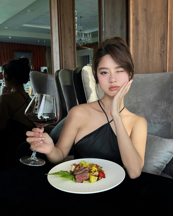 Mới đây, hot girl Hàn Hằng gây chú ý khi đi ăn ở một nhà hàng trong trang phục váy satin cổ yếm, dài đến gối.