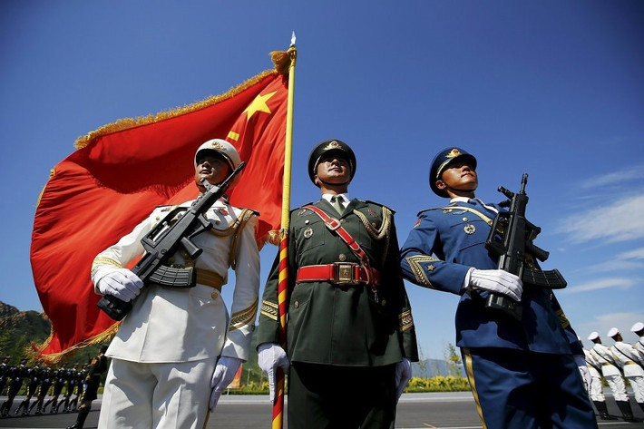 Binh sĩ Trung Quốc cầm cờ và vũ khí trong buổi tập duyệt binh.