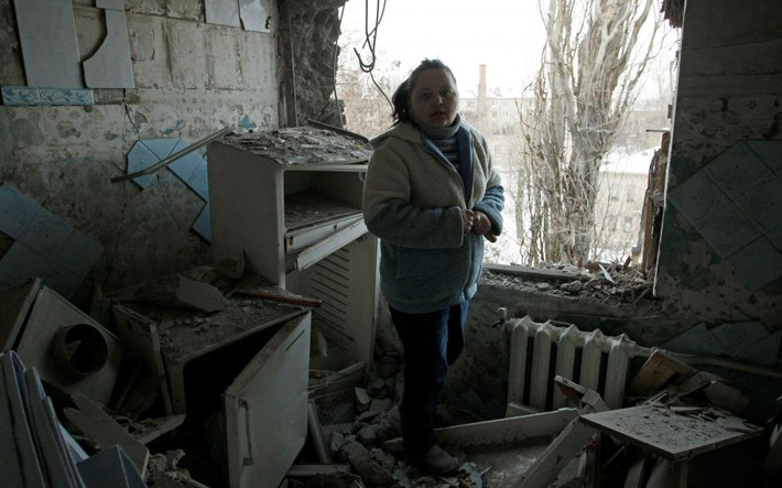 Người phụ nữ đứng trong ngôi nhà bị phá hủy trong các cuộc đụng độ giữa quân đội Ukraine và lực lượng đòi ly khai. Cơ quan An ninh và Hợp tác châu Âu cho biết, họ không thể ghi nhận được có bao nhiêu vụ nổ ở gần thị trấn Avdiyivka vào hôm 29/1 và hơn 4.000 vụ nổ hôm 30/1. Ảnh Reuters