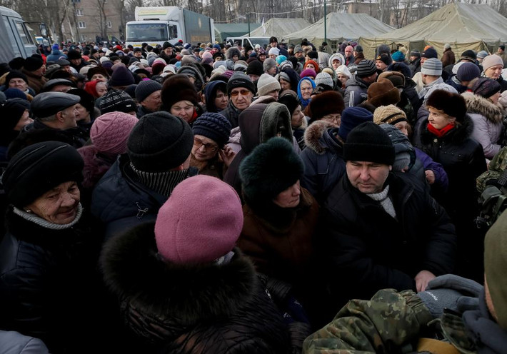 Người dân ở Avdiyivka đứng xếp hàng nhận đồ ăn cứu trợ sau các vụ bắn phá. Ảnh Reuters