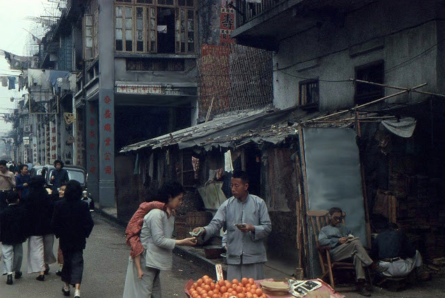 Người đàn ông bán hoa quả rong đang trả lại tiền thừa cho khách.