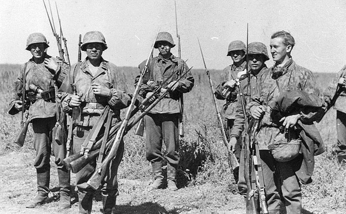 Tổng cộng đã có 37 triệu khẩu súng trường Mosin Nagant được ra đời trong thời gian từ năm 1891 cho tới tận năm... 1965 khi dây chuyền cuối cùng dừng sản xuất khẩu súng trường này. Ảnh: Lính biệt kích Đức trong Chiến tranh Thế giới thứ hai thu giữ súng trường Mosin Nagant của lính Hồng quân Liên Xô. Nguồn ảnh: Pinterest.