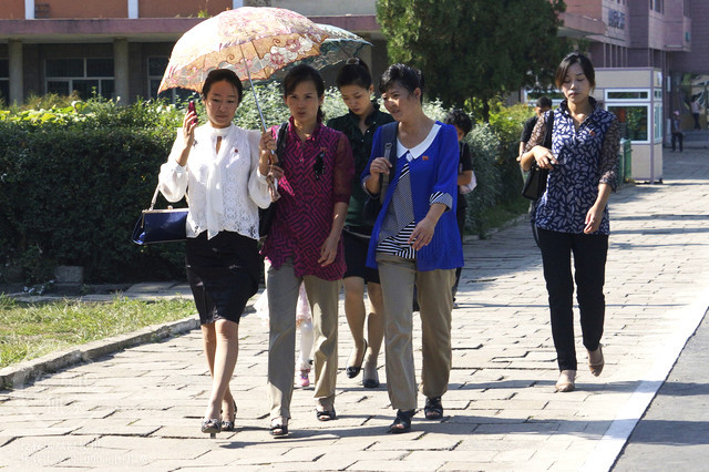 Một nhóm phụ nữ cùng nhau che ô vào một ngày hè nắng ở đất nước Triều Tiên.
