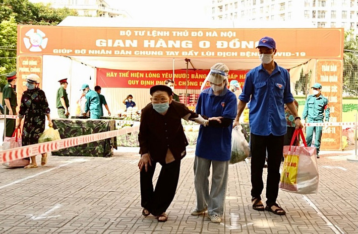 Các tình nguyện viên phường Mỹ Đình 1 giúp người khó khăn, người già mang những nhu yếu phẩm được tặng từ Gian hàng 0 đồng về tới tận nhà.