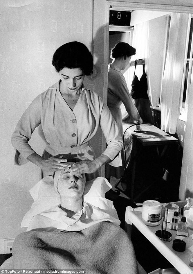 Bức ảnh được chụp tại Beauty Salon của Burlington Arcade tại London vào năm 1953. Người phụ nữ trong ảnh là Annette, cô được ủ kín trong chiếc chăn dày trong khi nhân viên thẩm mỹ massage mặt. Cùng lúc đó, một nhân viên khác đang giúp cô là váy để sẵn sàng cho một buổi tiệc tối.