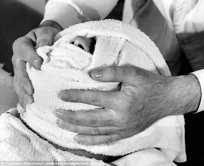 Nam giới thời này cũng yêu thích các phương pháp làm đẹp, thư giãn. Một người đàn ông được massage mặt bằng khăn ấm trong tiệm cắt tóc sang trọng.