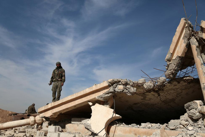 Một chiến binh Lực lượng Dân chủ Syria (SDF) đứng trên đống đổ nát của một tòa nhà nằm ở phía bắc thành phố Raqqa, Syria. Đây là một trong những hình ảnh mới nhất về chiến dịch giải phóng Raqqa. Ảnh Reuters