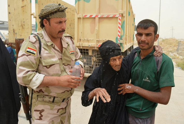 Lính Iraq giúp đỡ người dân ở Fallujah sau khi họ bỏ nhà cửa để chạy IS.